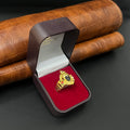 A gold ring displayed inside an open dark brown jewelry box with a red velvet lining, set against a brown textured leather background.